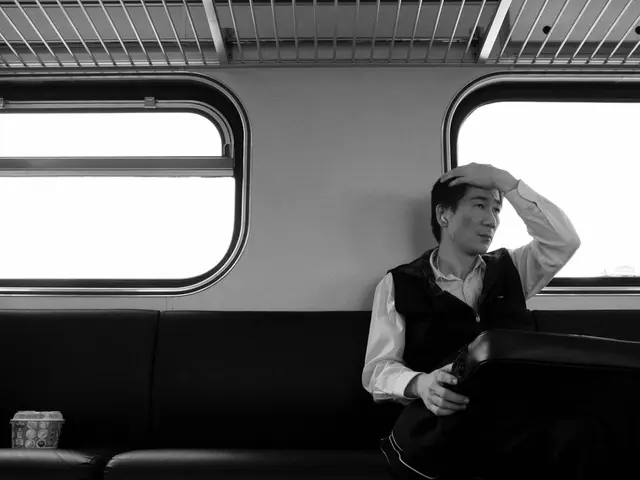 In this picture I can see a person holding an item and sitting on the seat ,inside a vehicle, there...